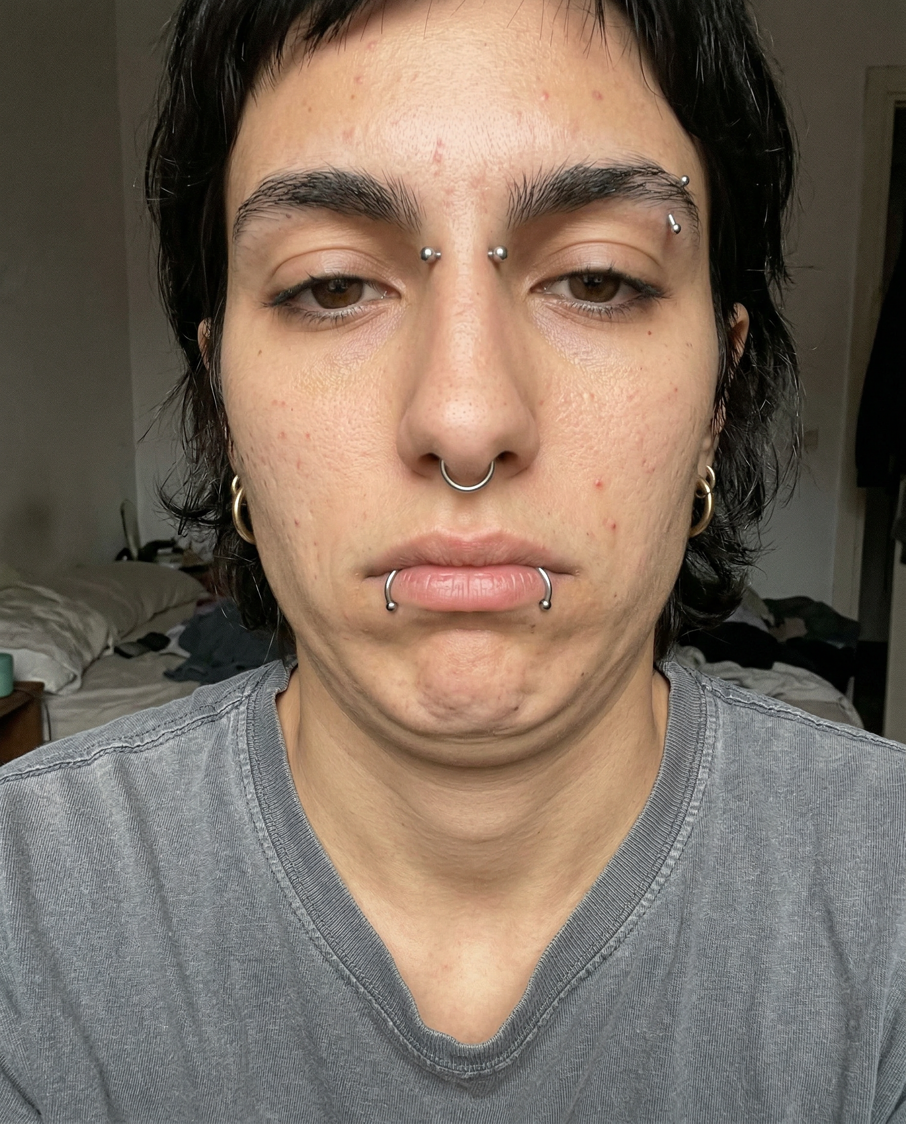 AI model training photo — tired selfie with natural skin and piercings